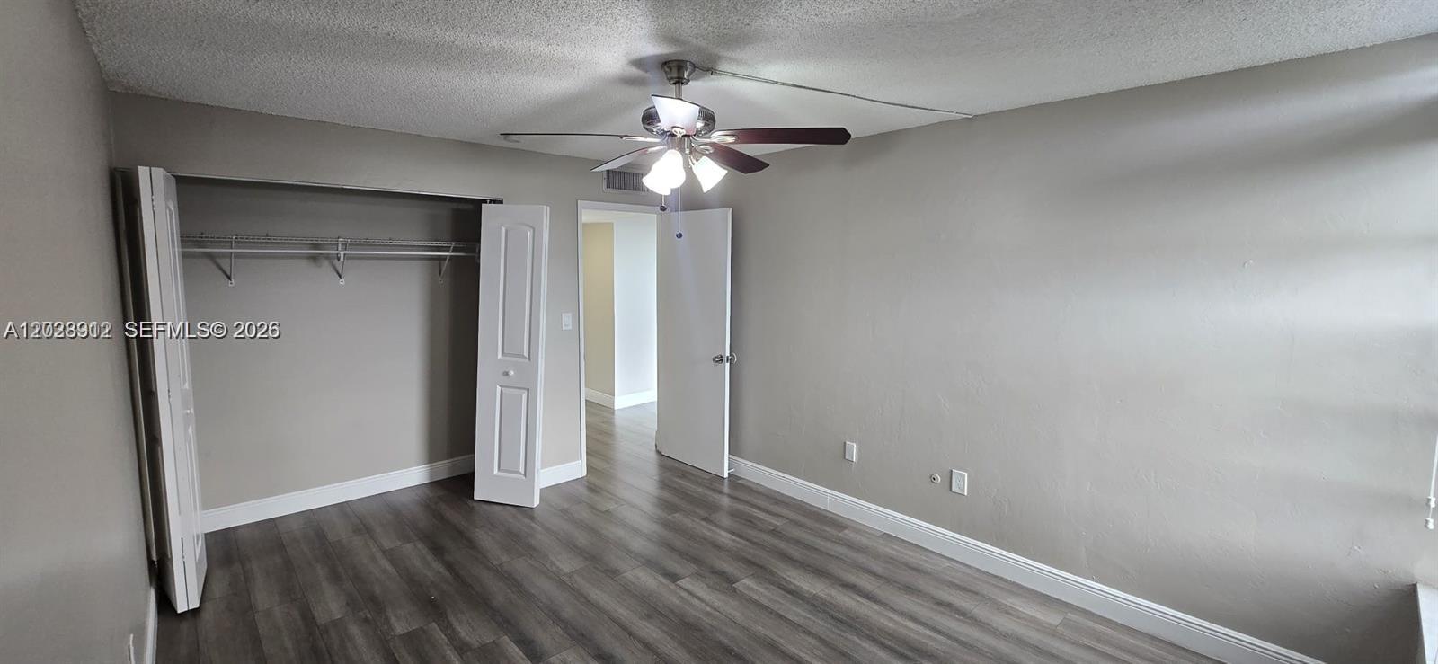 A bedroom features gray walls, wood-look flooring, a ceiling fan, and a closet with doors — 8870 Fontainebleau Blvd # 502, Miami FL 33172, MIAMI, FL