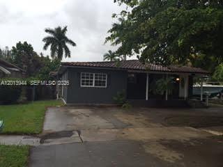A single-story house with a dark gray exterior, a tiled roof, and a concrete driveway — 335 NE 114th St # 1, Miami FL 33161, MIAMI, FL