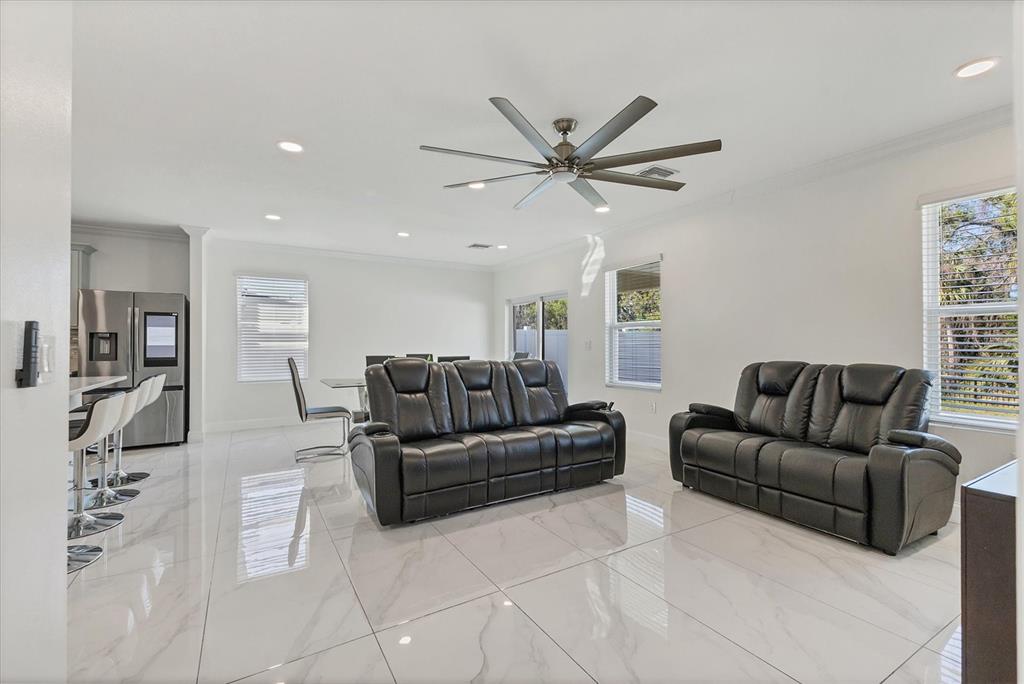 A living room with white tile floors, black leather sofas, and a ceiling fan — 177 TIERRA VERDE WAY, BRADENTON, FL