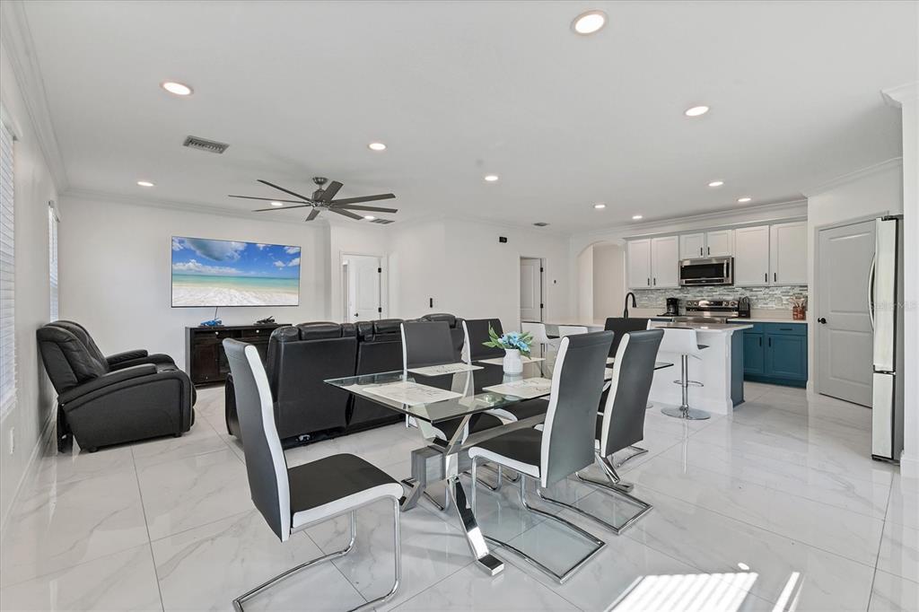 An open-concept living and dining area features white tile floors, modern furniture, and a kitchen — 177 TIERRA VERDE WAY, BRADENTON, FL