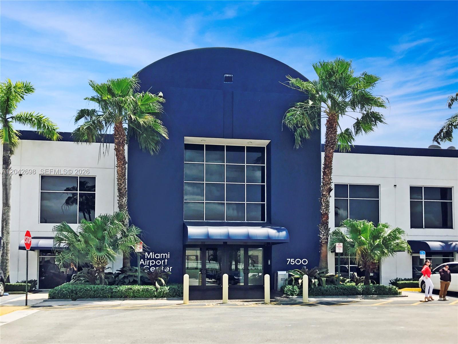 The exterior of a commercial building features a dark blue arched entrance with glass windows — 7500 NW 25th St # 256, Miami FL 33122, MIAMI, FL