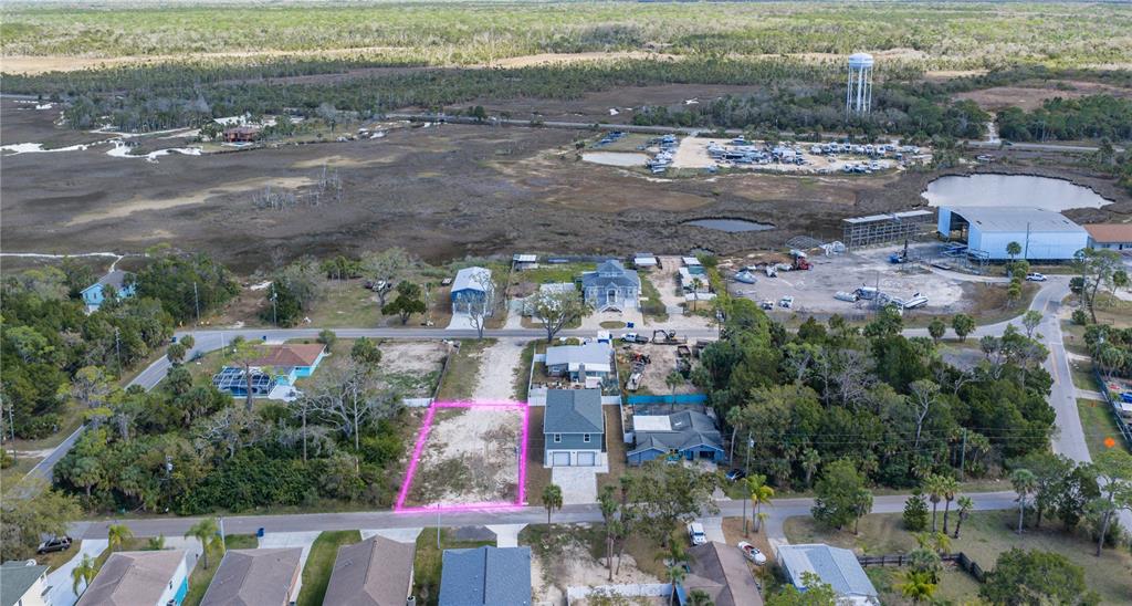 An aerial view shows a vacant rectangular lot outlined in pink near a coastal area — 5056 OAK LEAF LANE, HERNANDO BEACH, FL