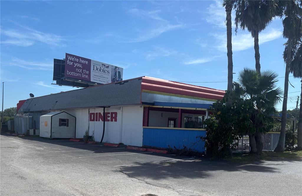 A single-story commercial diner building with a parking lot and a large billboard on top — 1730 US HIGHWAY 19, HOLIDAY, FL