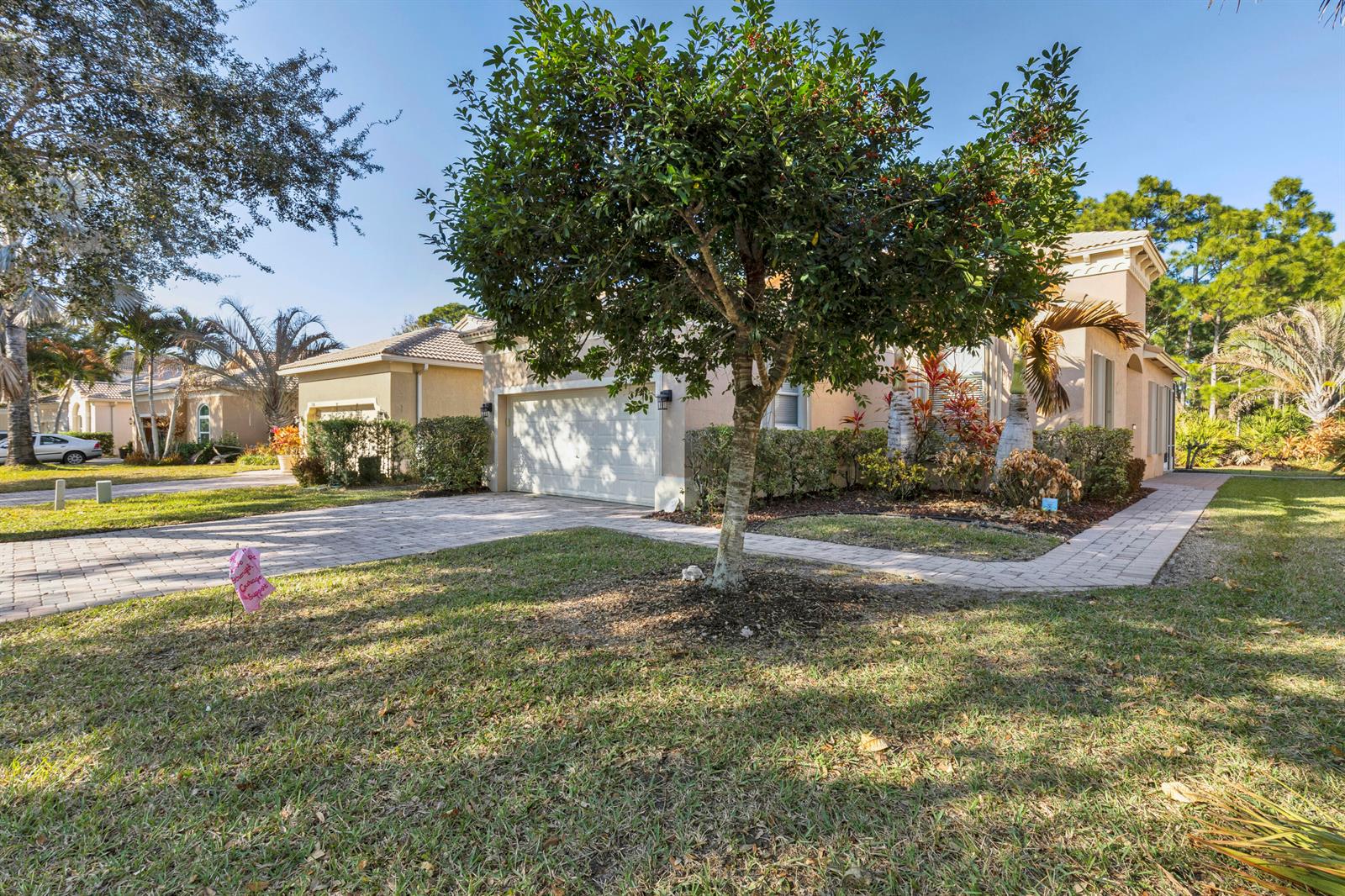 A single-story house with a paved driveway, a two-car garage, and a large front tree — 5726 Sterling Lake Drive, Fort Pierce FL 34951, FORT PIERCE, FL