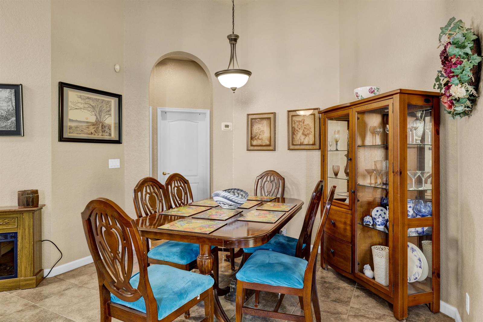 A dining room features a wooden table with blue chairs, a hutch, and tiled floors — 5726 Sterling Lake Drive, Fort Pierce FL 34951, FORT PIERCE, FL
