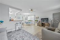 A living room features a light gray sofa, a recliner, and an open kitchen pass-through — 11923 BOYNTON LANE UNIT B, NEW PORT RICHEY, FL