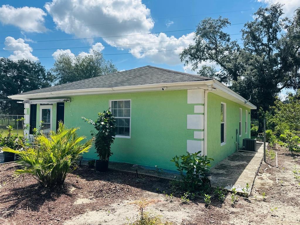 A lime green, single-story house with white corner accents and a dark shingled roof — 224 MONTEGO DRIVE, SEBRING, FL