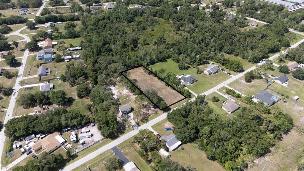 An aerial view shows a rectangular vacant lot outlined in black within a residential neighborhood — 0 HEDGEROW DRIVE, WESLEY CHAPEL, FL