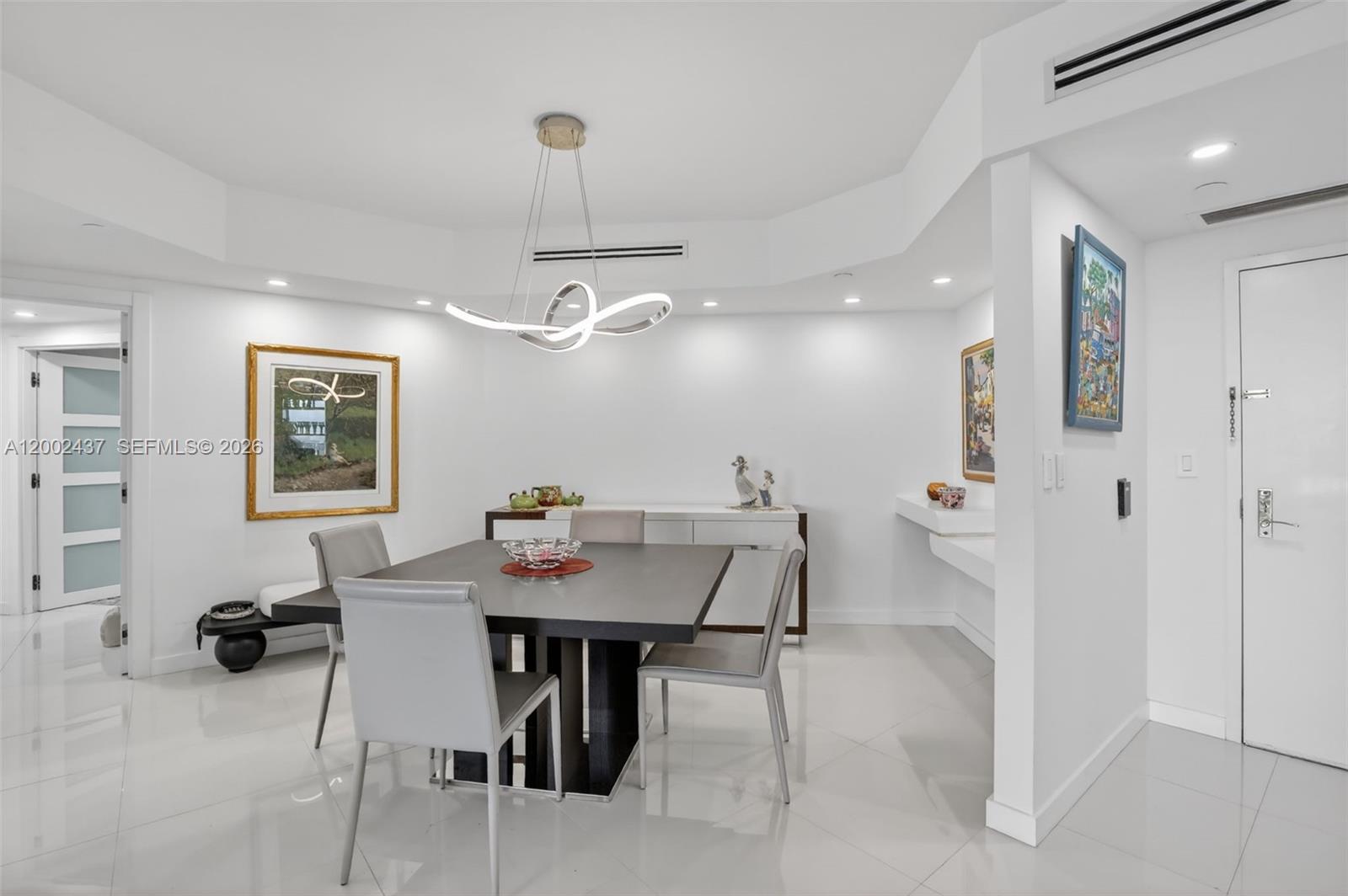 A dining room features a dark square table, gray chairs, and a modern light fixture — 3000 Island Blvd # 2404, Aventura FL 33160, AVENTURA, FL