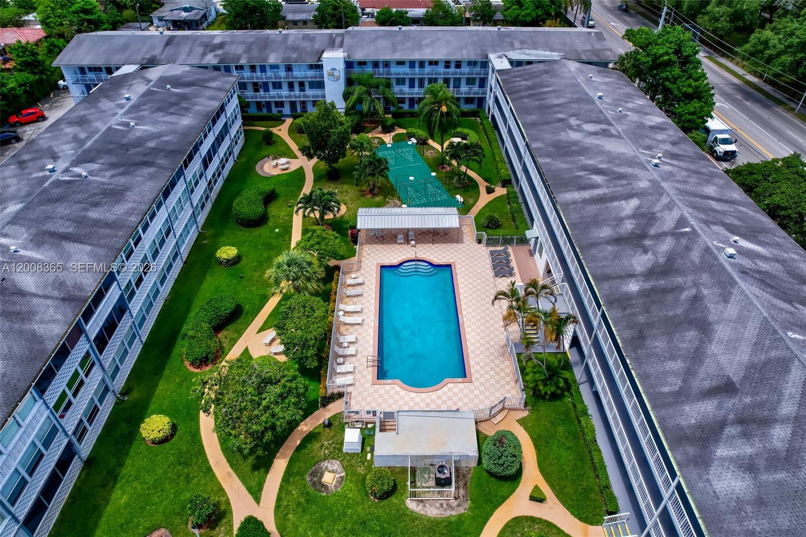 An aerial view shows a residential apartment complex with a central swimming pool and courtyard — 15610 NE 6th Ave # 23C, Miami FL 33162, MIAMI, FL