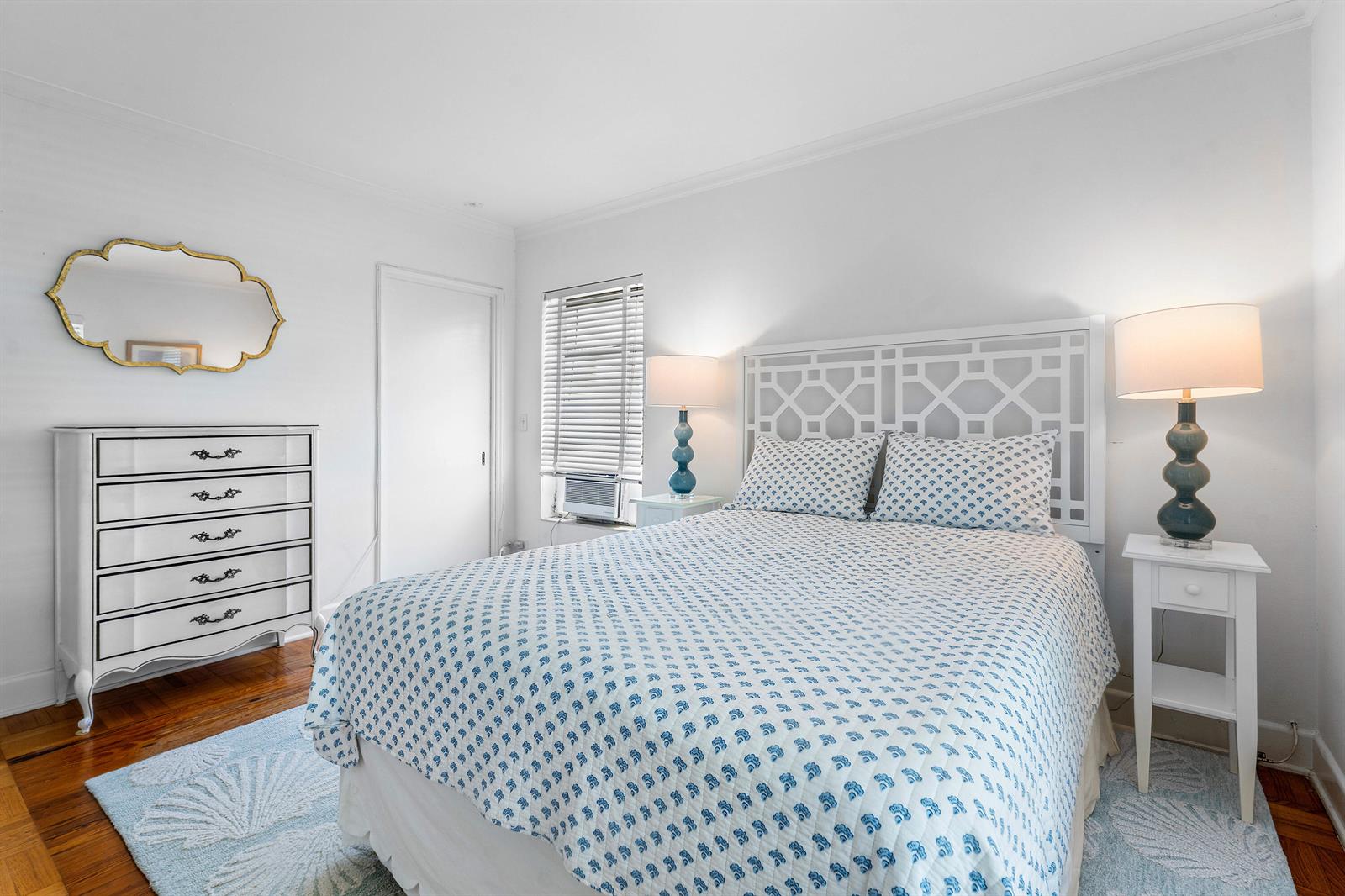 A bedroom features a white bed with patterned bedding, two nightstands, and a white dresser — 424 Chilean Avenue # 4, Palm Beach FL 33480, PALM BEACH, FL