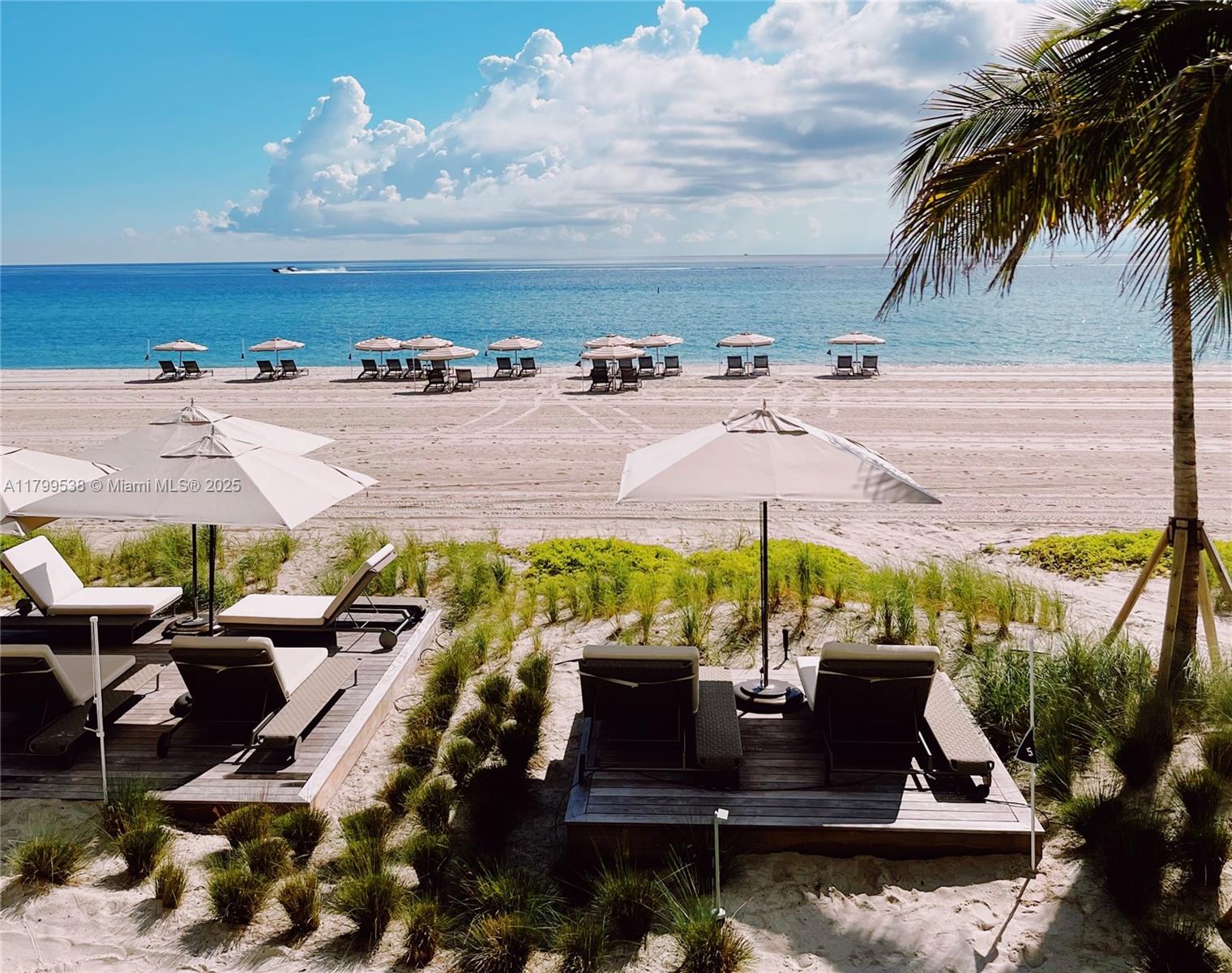 A beach view features lounge chairs and umbrellas on wooden decks overlooking the ocean — 18501 Collins Avenue # 27, Sunny Isles Beach FL 33160, SUNNY ISLES BEACH, FL