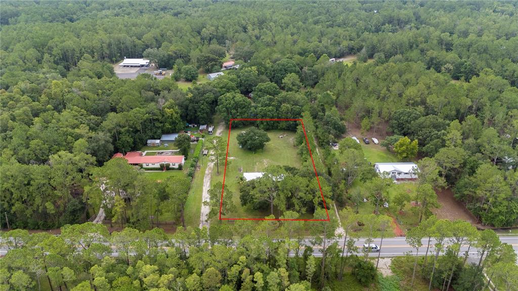 An aerial view shows a rectangular lot outlined in red featuring a house and trees — 13821 ROCKRIDGE ROAD, LAKELAND, FL