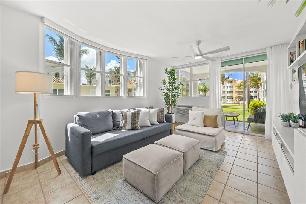 A dining area with a round white table and chairs sits before a living room — Haudimar Beach Apartments 400 4466 ROAD UNIT H102, ISABELA, PR