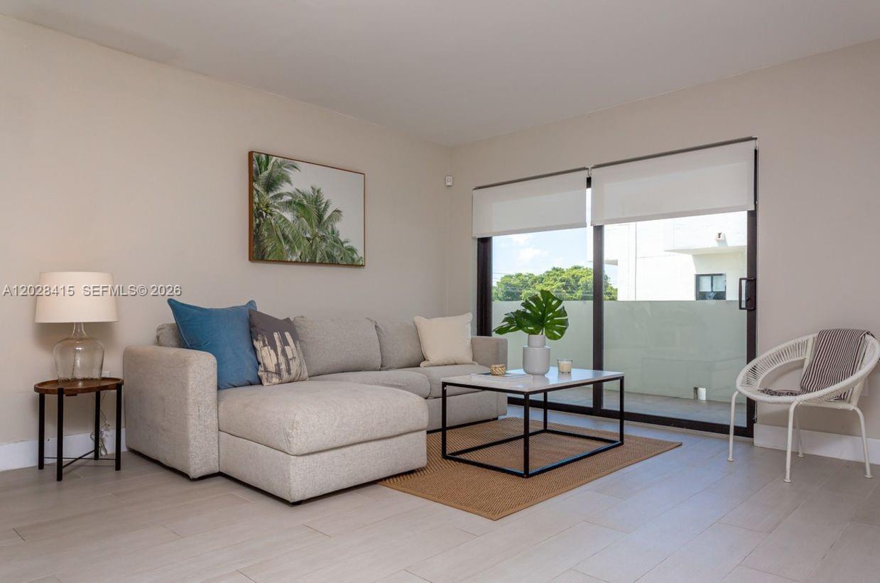 A living room features a light gray sectional sofa, a coffee table, and a balcony door — 800 S Dixie Hwy 208 Hwy # 208, Coral Gables FL 33146, CORAL GABLES, FL