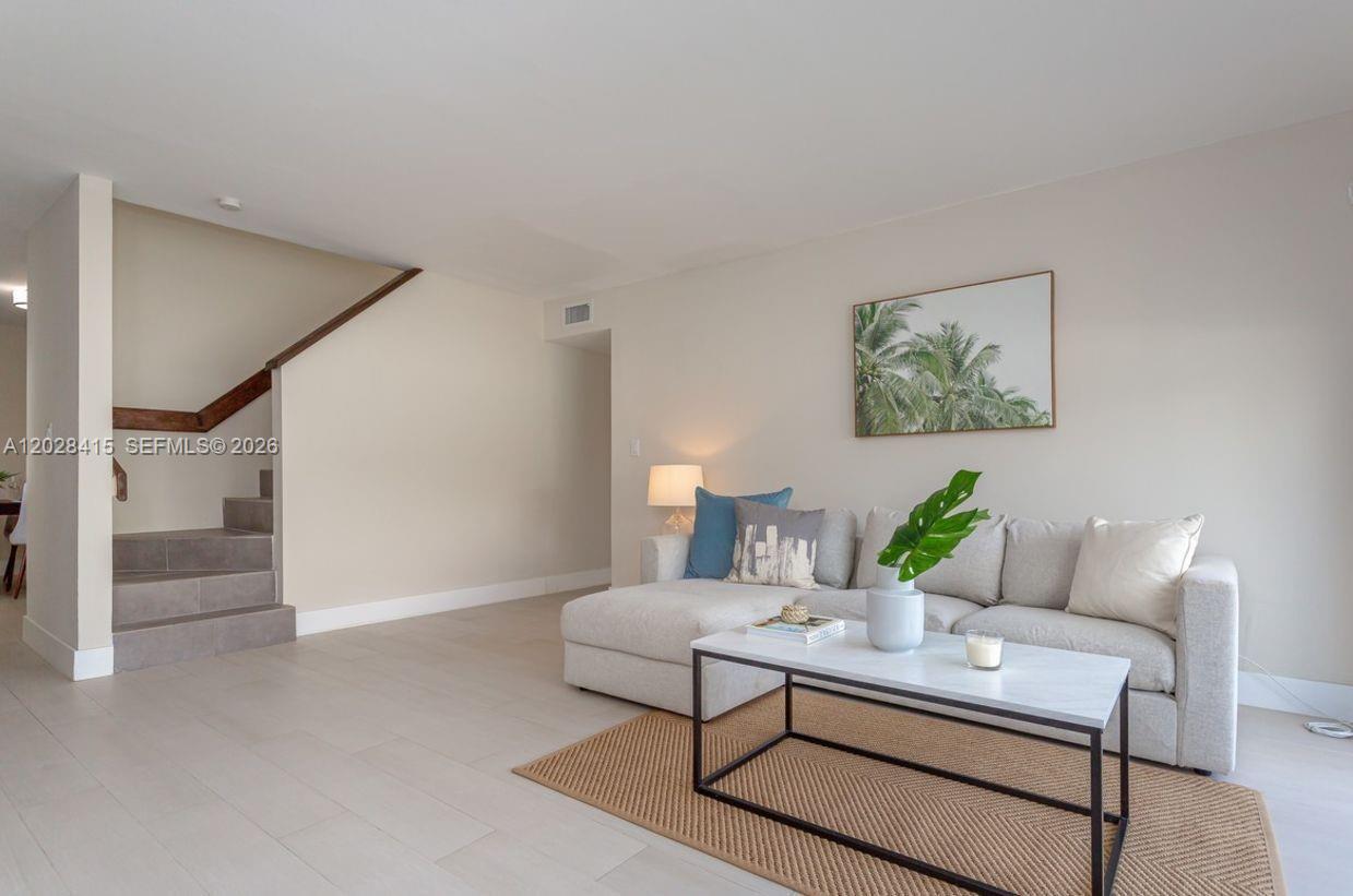 A living room features a light-colored sectional sofa, a marble coffee table, and stairs — 800 S Dixie Hwy 208 Hwy # 208, Coral Gables FL 33146, CORAL GABLES, FL