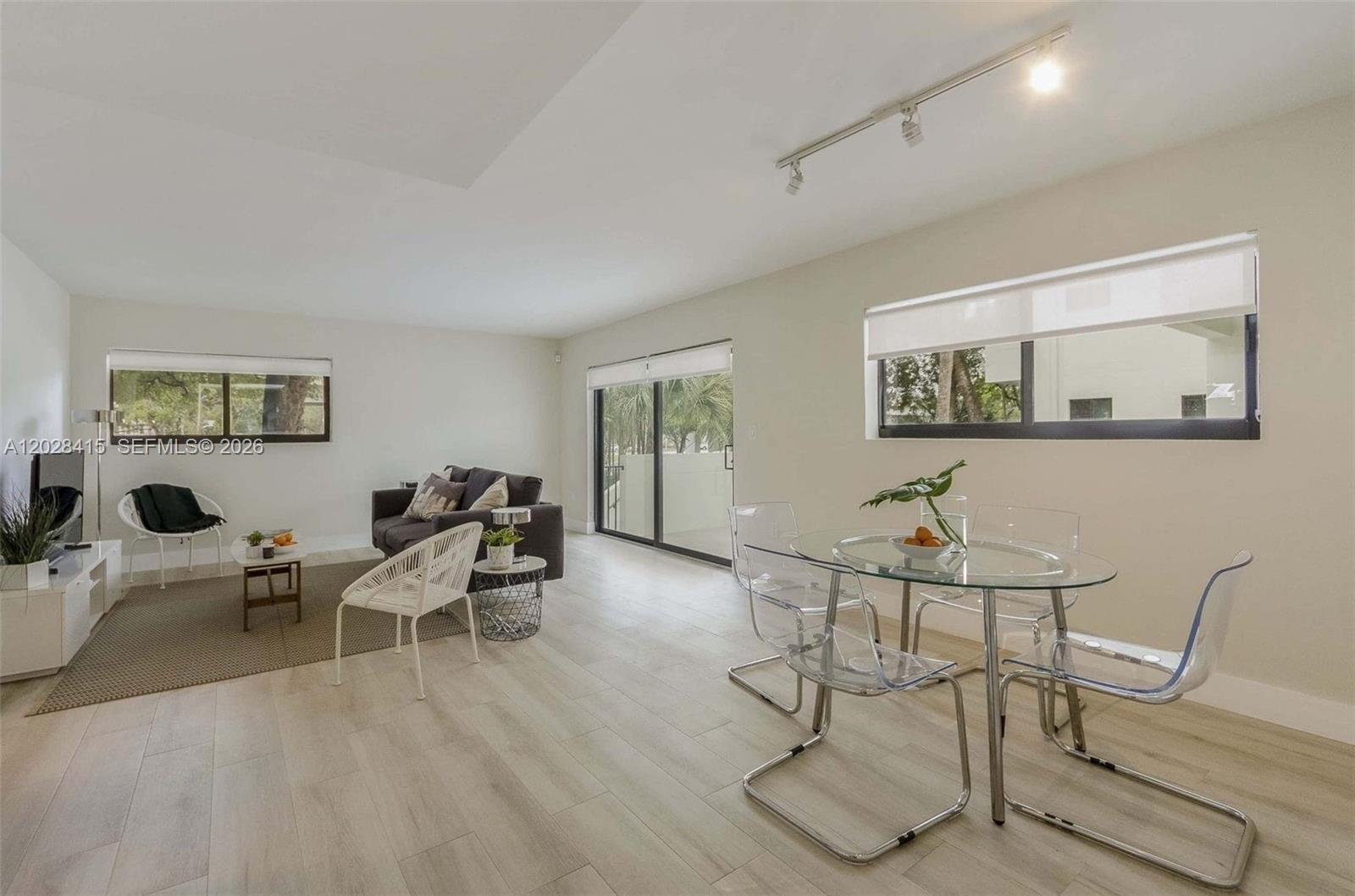 A living and dining area features light wood-look flooring, white walls, and modern furniture — 800 S Dixie Hwy 208 Hwy # 208, Coral Gables FL 33146, CORAL GABLES, FL
