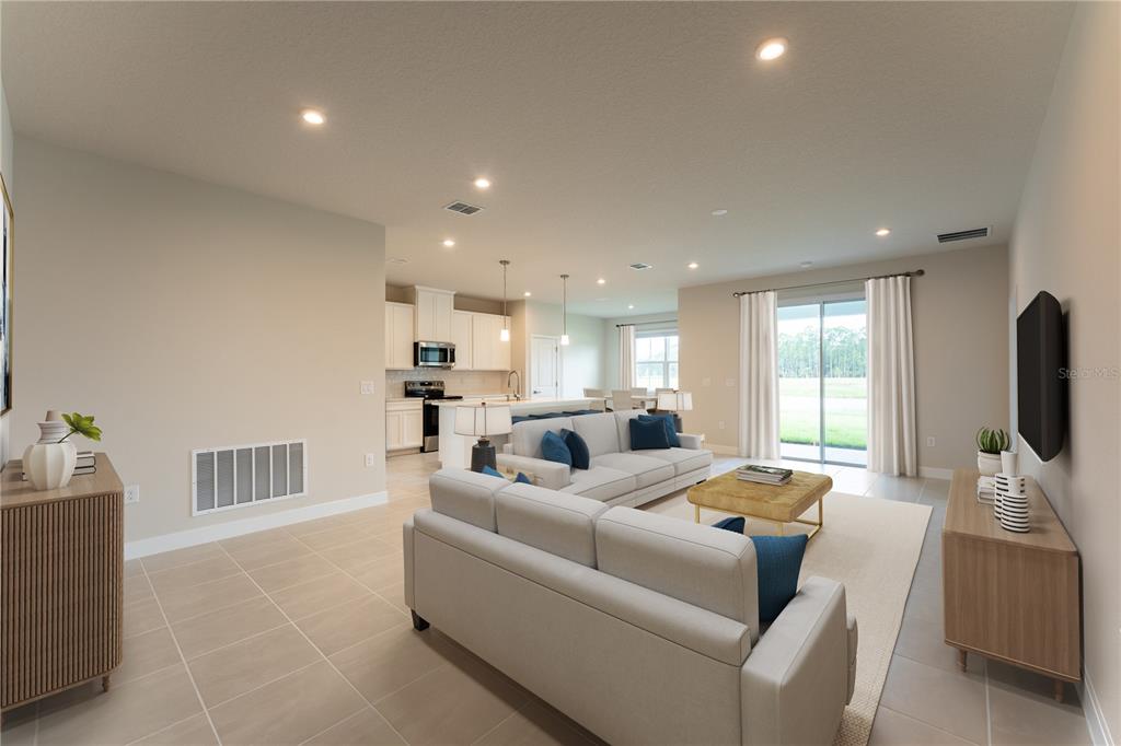 A bright, open-concept living room and kitchen featuring light tile floors and neutral walls — 123 VENETIAN PALMS BOULEVARD, NEW SMYRNA BEACH, FL