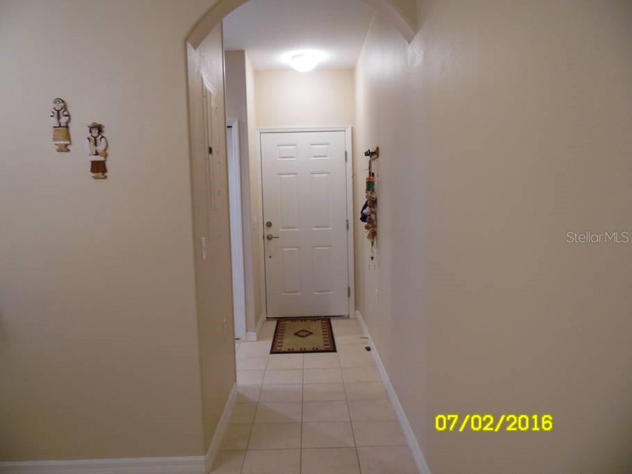 A tiled entryway features a white front door, an arched ceiling, and wall-mounted decorations — 12959 TIGERS EYE DRIVE, VENICE, FL