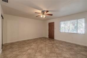 An empty room with tiled floors, a ceiling fan, and a window — 102 S PENINSULA DRIVE UNIT 201, DAYTONA BEACH, FL