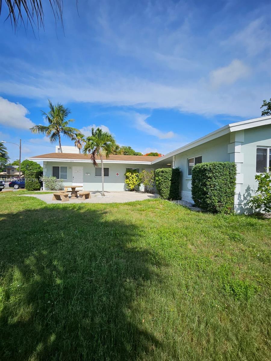A light green single-story building with a patio, picnic table, and palm trees — 1231 NE 23rd Ave, Pompano Beach FL 33062, POMPANO BEACH, FL