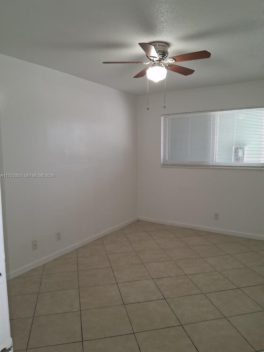 An empty room features white walls, a ceiling fan, and light-colored tile flooring — 1231 NE 23rd Ave, Pompano Beach FL 33062, POMPANO BEACH, FL