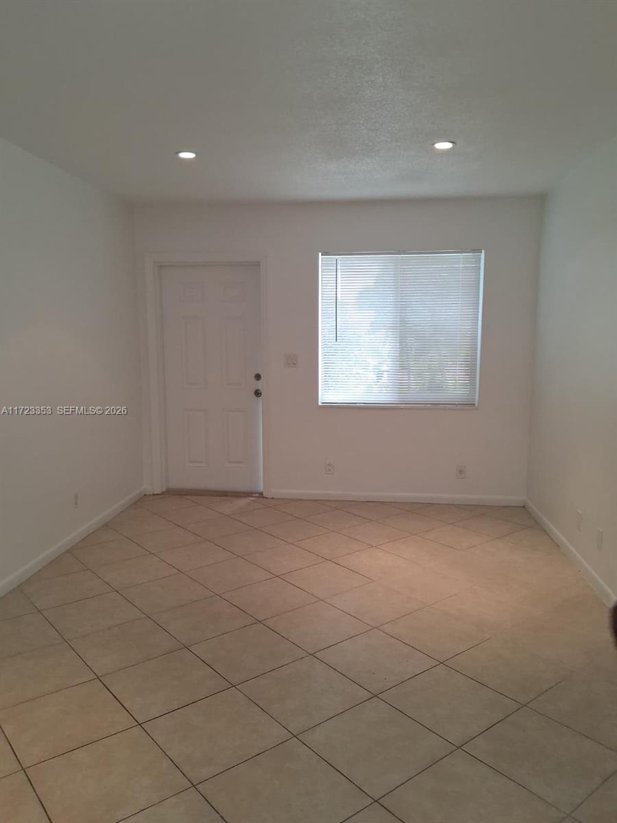 A room with white walls, a white door, a window with blinds, and tiled flooring — 1231 NE 23rd Ave, Pompano Beach FL 33062, POMPANO BEACH, FL