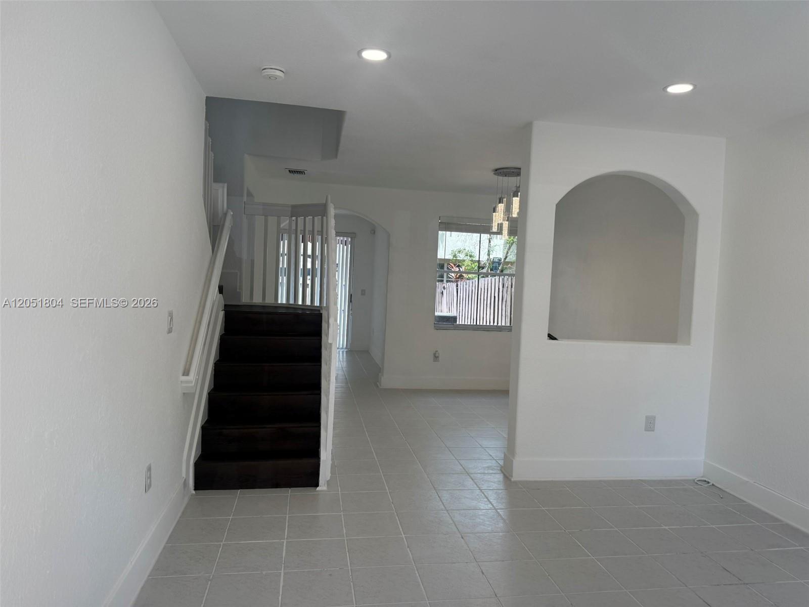 An interior view shows a tiled living area with a staircase and an arched wall niche — 3873 SW 171st Ter0, Miramar FL 33027, MIRAMAR, FL