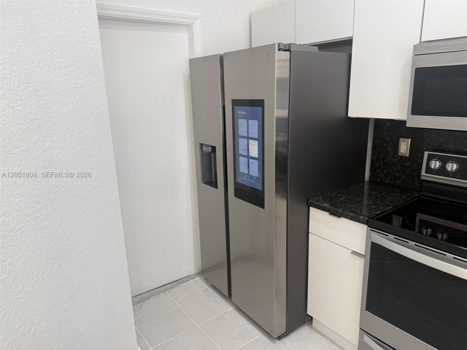 A kitchen features a stainless steel smart refrigerator, white cabinets, and a black electric stove — 3873 SW 171st Ter0, Miramar FL 33027, MIRAMAR, FL