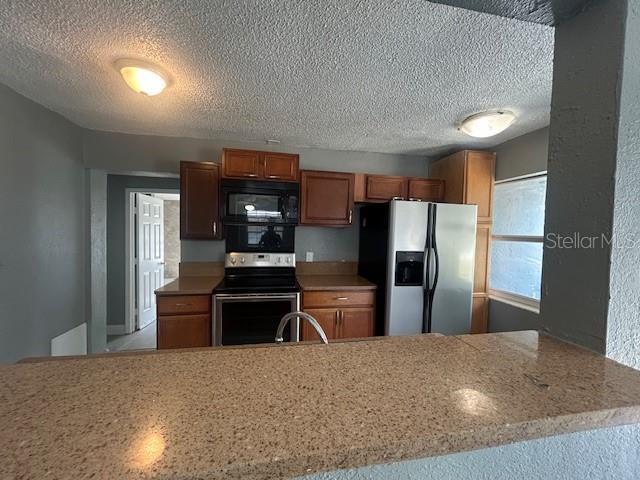 A kitchen features wood cabinets, stainless steel appliances, and a granite-topped breakfast bar — 1025 25TH STREET, ORLANDO, FL