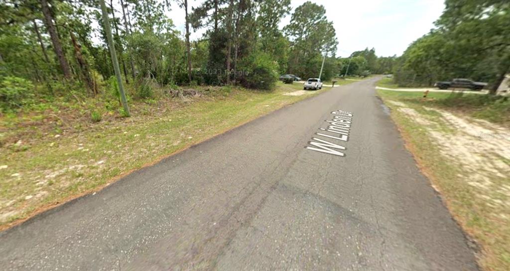 A paved road winds through a wooded area with scattered houses and grassy shoulders — 2078 W LINDEN DRIVE, CITRUS SPRINGS, FL
