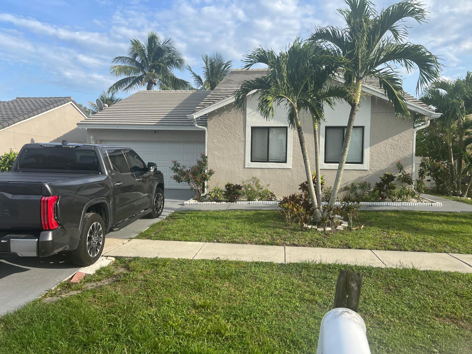A single-story house with a gray truck parked in the driveway and palm trees — 5765 Strawberry Lakes Circle, Lake Worth FL 33463, LAKE WORTH, FL