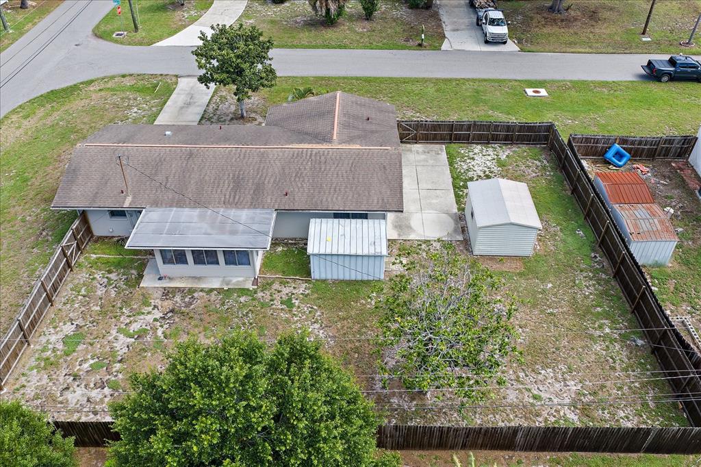 An aerial view shows a house with a fenced backyard, two sheds, and a patio — 1210 DORIS DRIVE, SARASOTA, FL