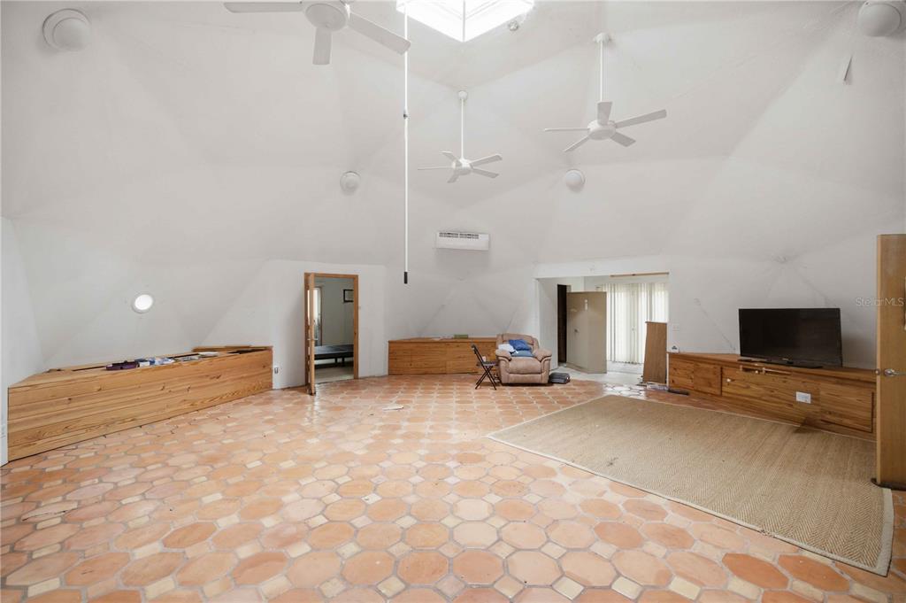 A large, circular room with a domed ceiling, tile flooring, and built-in wooden cabinetry — 12897 NW HIGHWAY 225, REDDICK, FL