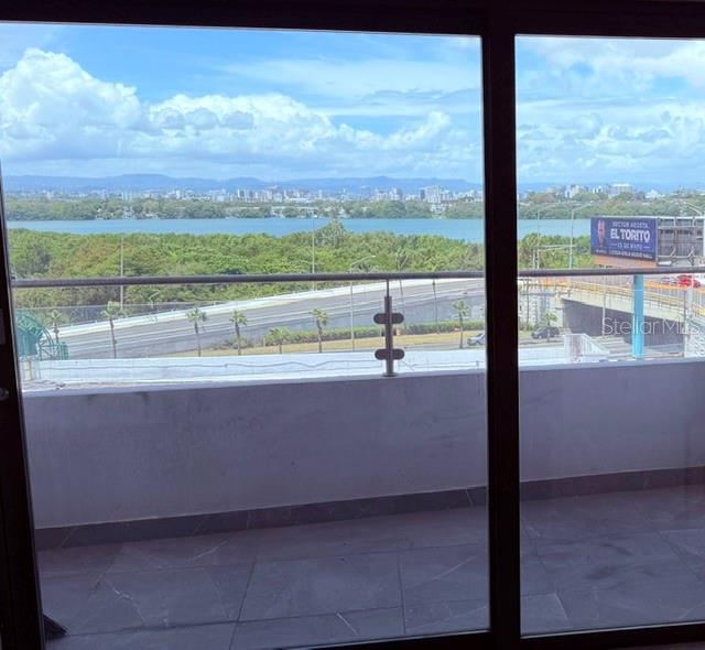 A view from a balcony overlooking a highway, a body of water, and a city skyline — 4123 ISLA VERDE AVENUE UNIT 602, CAROLINA, PR
