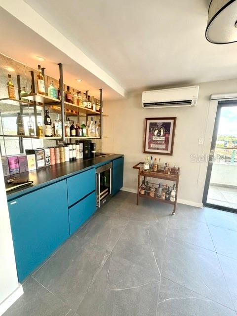 A modern home bar features teal cabinets, open shelving, and a rolling bar cart — 4123 ISLA VERDE AVENUE UNIT 602, CAROLINA, PR