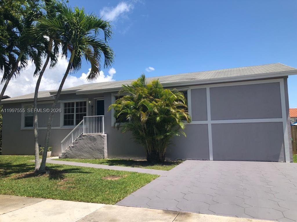 A single-story house with gray siding, a paved driveway, and palm trees in the front yard — 9771 SW 211th st, Cutler Bay FL 33189, CUTLER BAY, FL