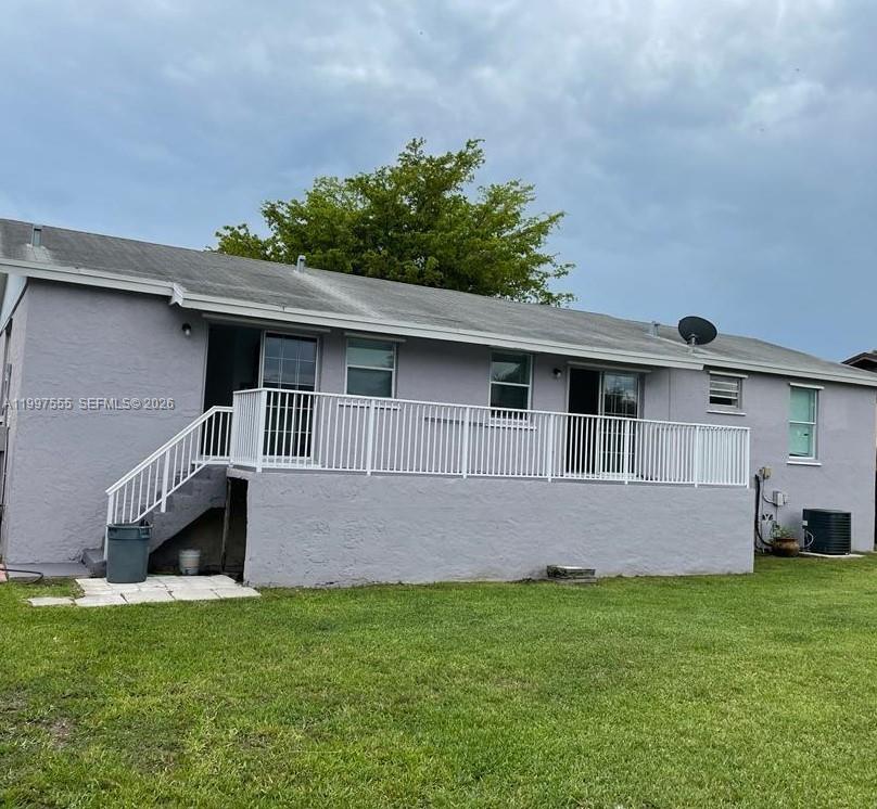 The exterior of a single-story house features a raised deck with a white railing — 9771 SW 211th st, Cutler Bay FL 33189, CUTLER BAY, FL