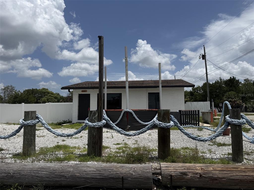 A small white building sits behind a rope fence supported by wooden posts — 8061 CORTEZ BOULEVARD, WEEKI WACHEE, FL