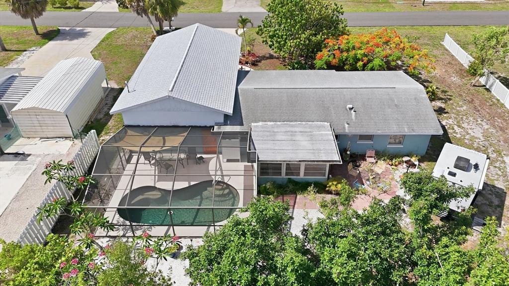An aerial view shows a house with a screened-in pool, patio, and detached carport — 852 E 6TH STREET, ENGLEWOOD, FL