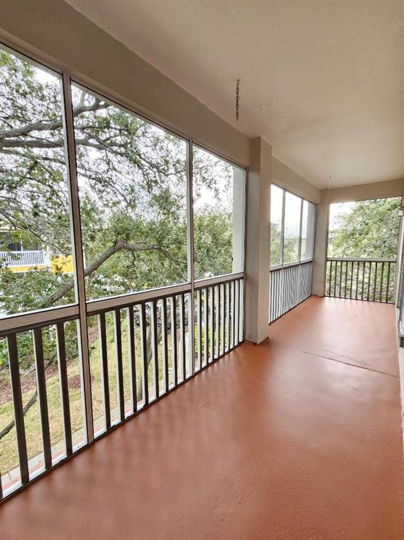 A screened-in balcony with a painted floor, metal railings, and views of surrounding trees — 4207 S DALE MABRY HIGHWAY UNIT 10310, TAMPA, FL