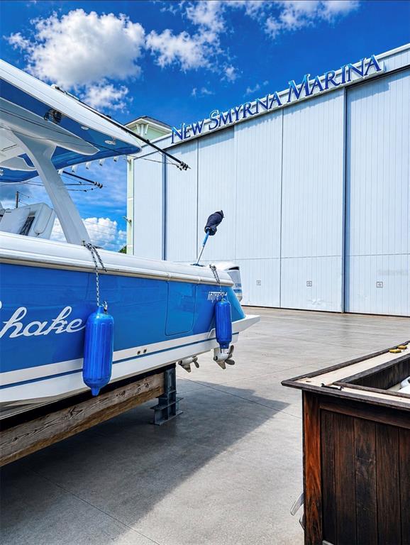 A blue and white boat sits on a stand outside the New Smyrna Marina building — 100 BOAT YARD STREET UNIT D10, NEW SMYRNA BEACH, FL