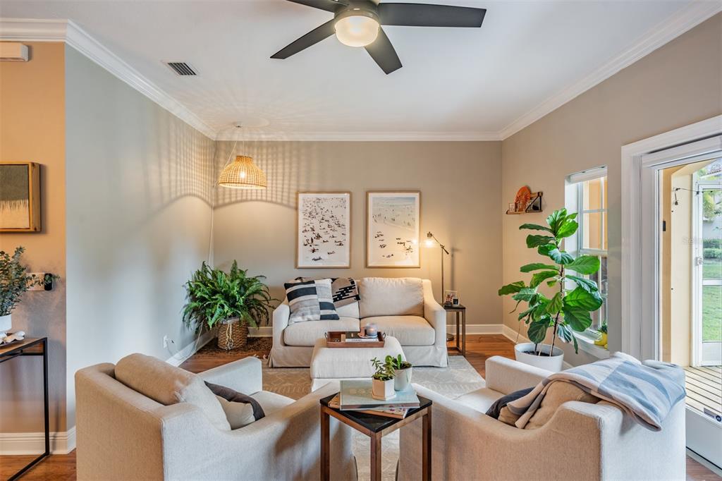 A living room features a sofa, two armchairs, a ceiling fan, and indoor plants — 415 BARCELONA DRIVE, ST PETERSBURG, FL