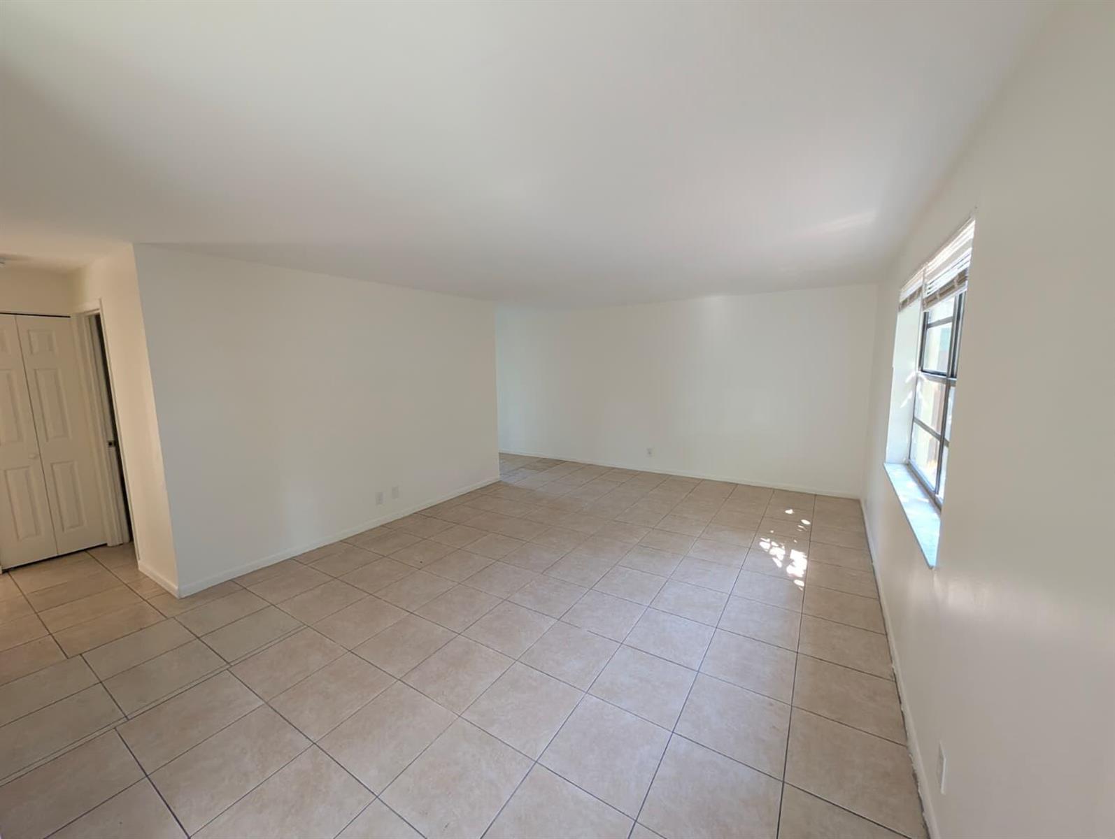 An empty room with beige tile flooring, white walls, and a window on the right — 4453 Steven Road # 2, Lake Worth FL 33461, LAKE WORTH, FL