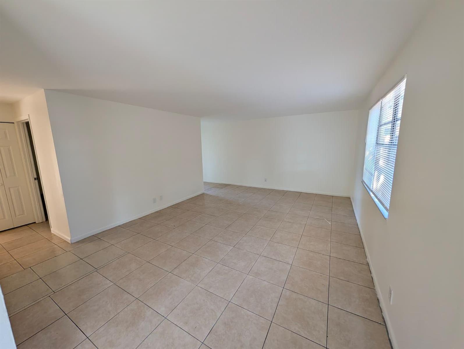 An empty room with beige tile flooring, white walls, and a window with blinds — 4453 Steven Road # 2, Lake Worth FL 33461, LAKE WORTH, FL
