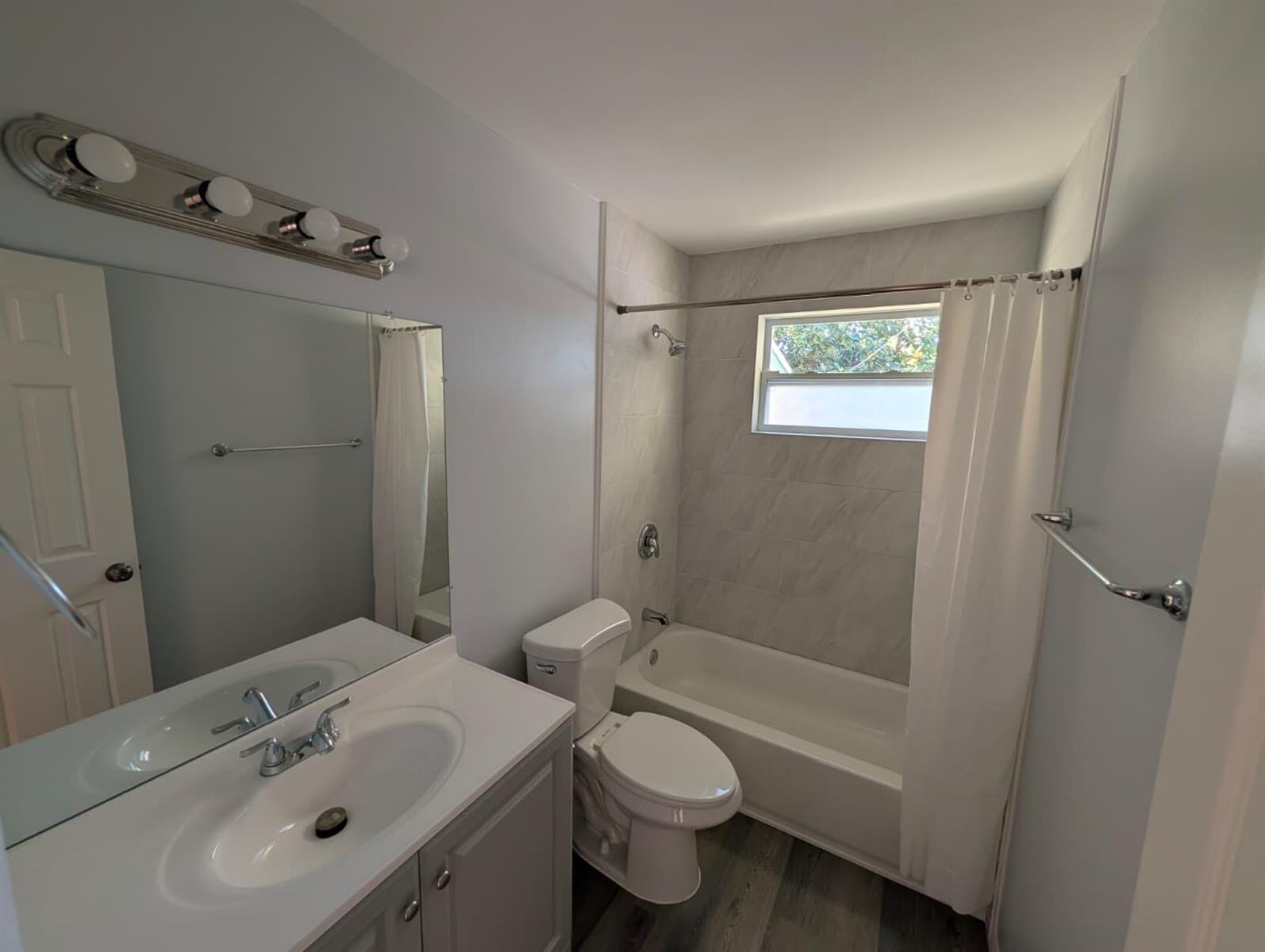 A bathroom featuring a vanity with a mirror, a toilet, and a tiled shower-tub combo — 4453 Steven Road # 2, Lake Worth FL 33461, LAKE WORTH, FL