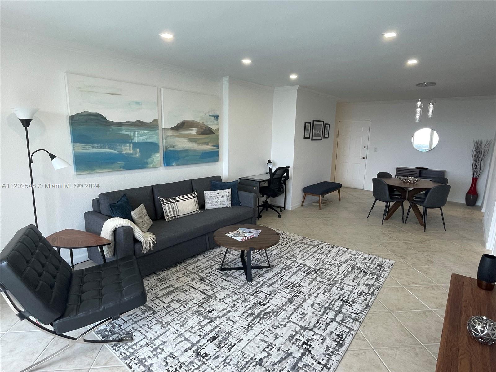 A living and dining area features a gray sofa, patterned rug, and modern furniture — 2501 S Ocean Dr, Hollywood FL 33019, HOLLYWOOD, FL