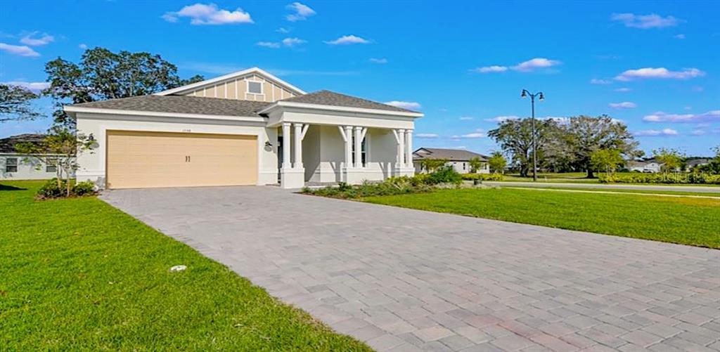 A single-story house with a beige garage and a paved driveway under a blue sky — 1598 WHITEWOOD COURT, KISSIMMEE, FL