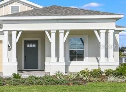 A front view of a house exterior featuring a covered porch with white columns — 1598 WHITEWOOD COURT, KISSIMMEE, FL