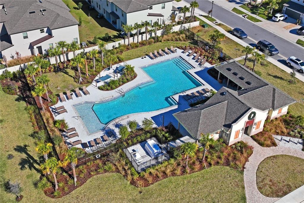 An aerial view of a community swimming pool with lounge chairs and a clubhouse — 8239 CRESCENT OAKS DRIVE, NEW PORT RICHEY, FL